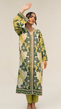 A woman modeling a long-sleeved printed kurta in olive green and beige with a botanical pattern, paired with olive green pants, in a minimalist studio setting.